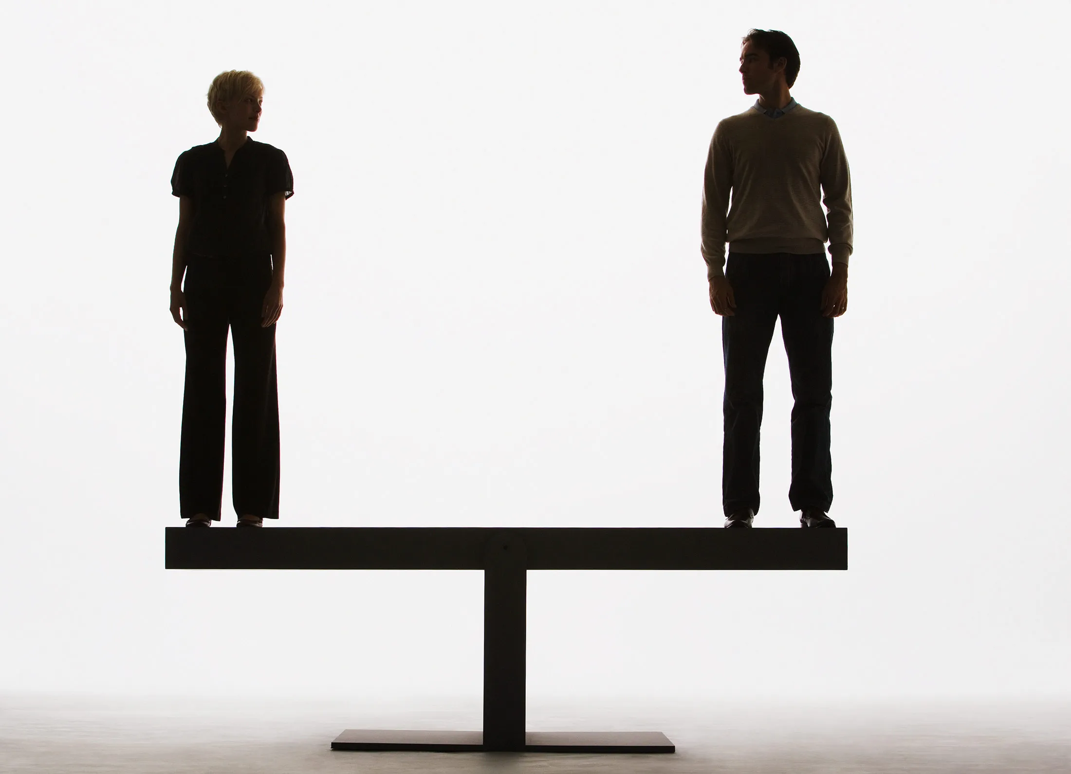 Two people standing on top of a plank