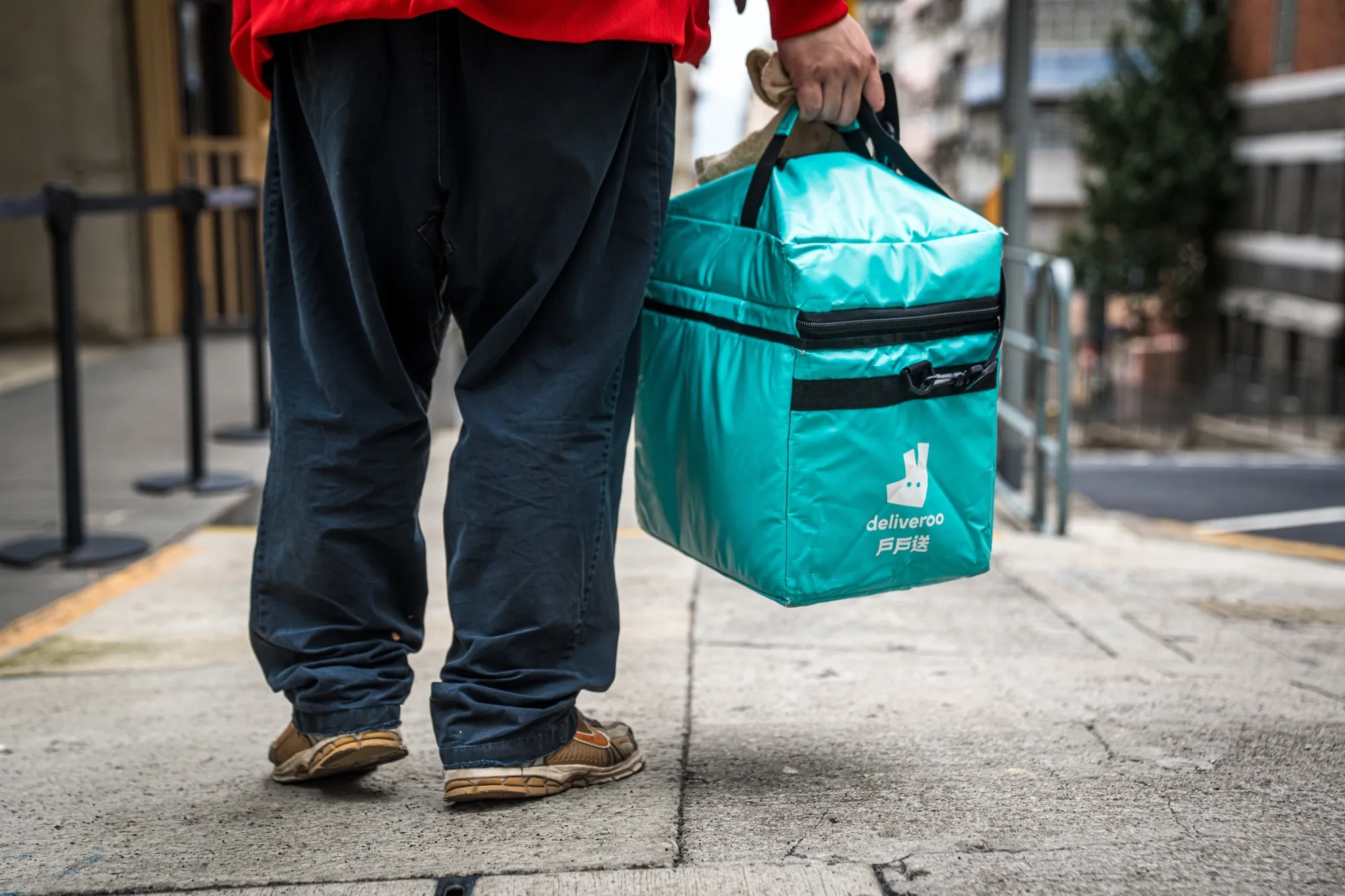 A food delivery courier for Deliveroo carries an insulated bag in Hong Kong.