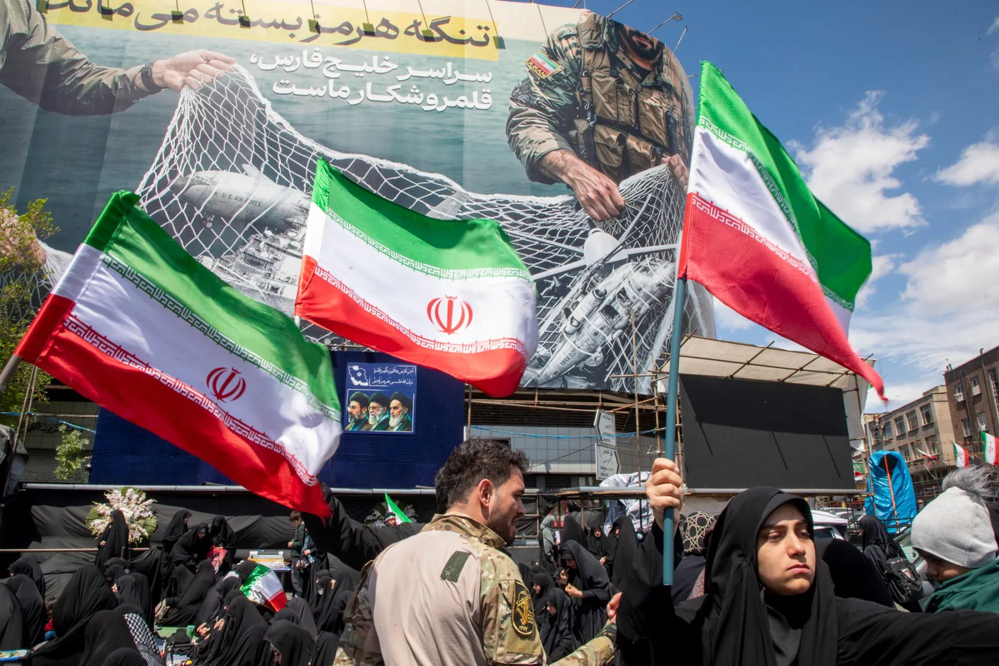 People hold national flags in Tehran's Revolution Square on April 8.