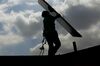 A SolarCity Corp. employee carries a solar panel during an installation at a home in the Eagle Rock neighborhood of Los Angeles, California, U.S.