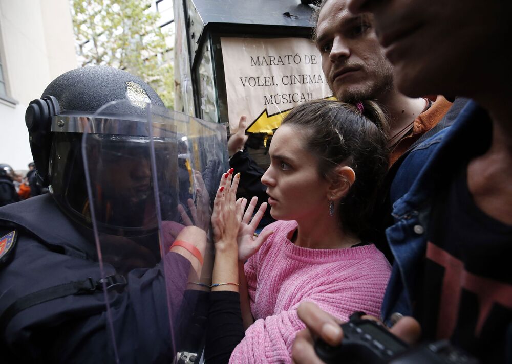 Spanish police push people with a shield outside a polling station in Barcelona.