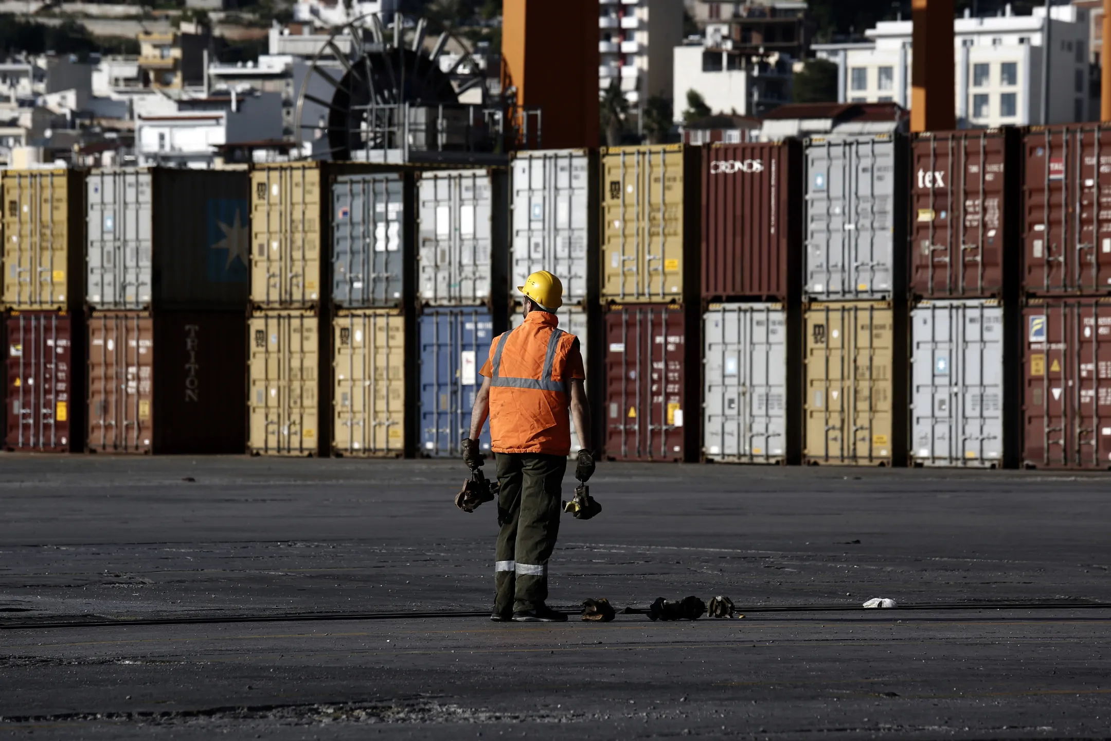 A dock worker holds security bolts during shipping container loading operations at the container terminal in the Port of Piraeus, operated by Piraeus Port Authority SA, in Piraeus, Greece, on Tuesday, Oct. 27, 2015. Greece is aiming to lease 14 regional airports and line up the sale of a majority stake in the port of Piraeus before the end of the year as the government attempts to rev up asset sales that have consistently failed to live up to expectations through successive bailouts.