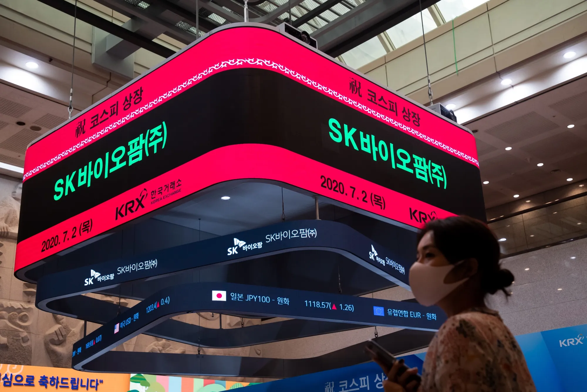 An attendee stands underneath a screen during the SK Biopharmaceuticals Co.'s IPO ceremony at the Korea Exchange (KRX) in Seoul on July 2.