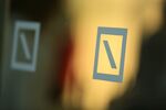 Deutsche Bank AG logos sit on a glass panel during the German Institute for Economic Research in Berlin (DIW) women's finance summit, inside Deutsche Bank's offices in Berlin, Germany.