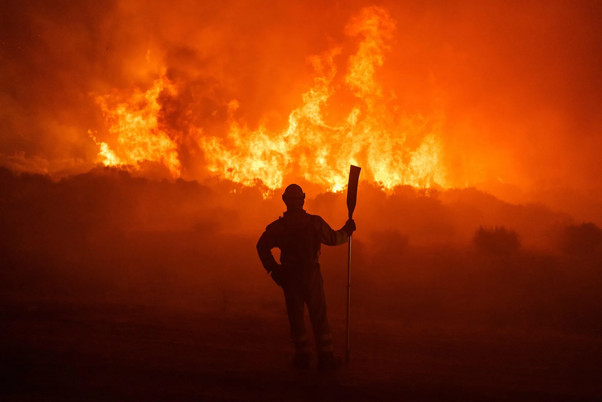 Firefighters operate at the site of a wildfire between Navalacruz and Riofrio.