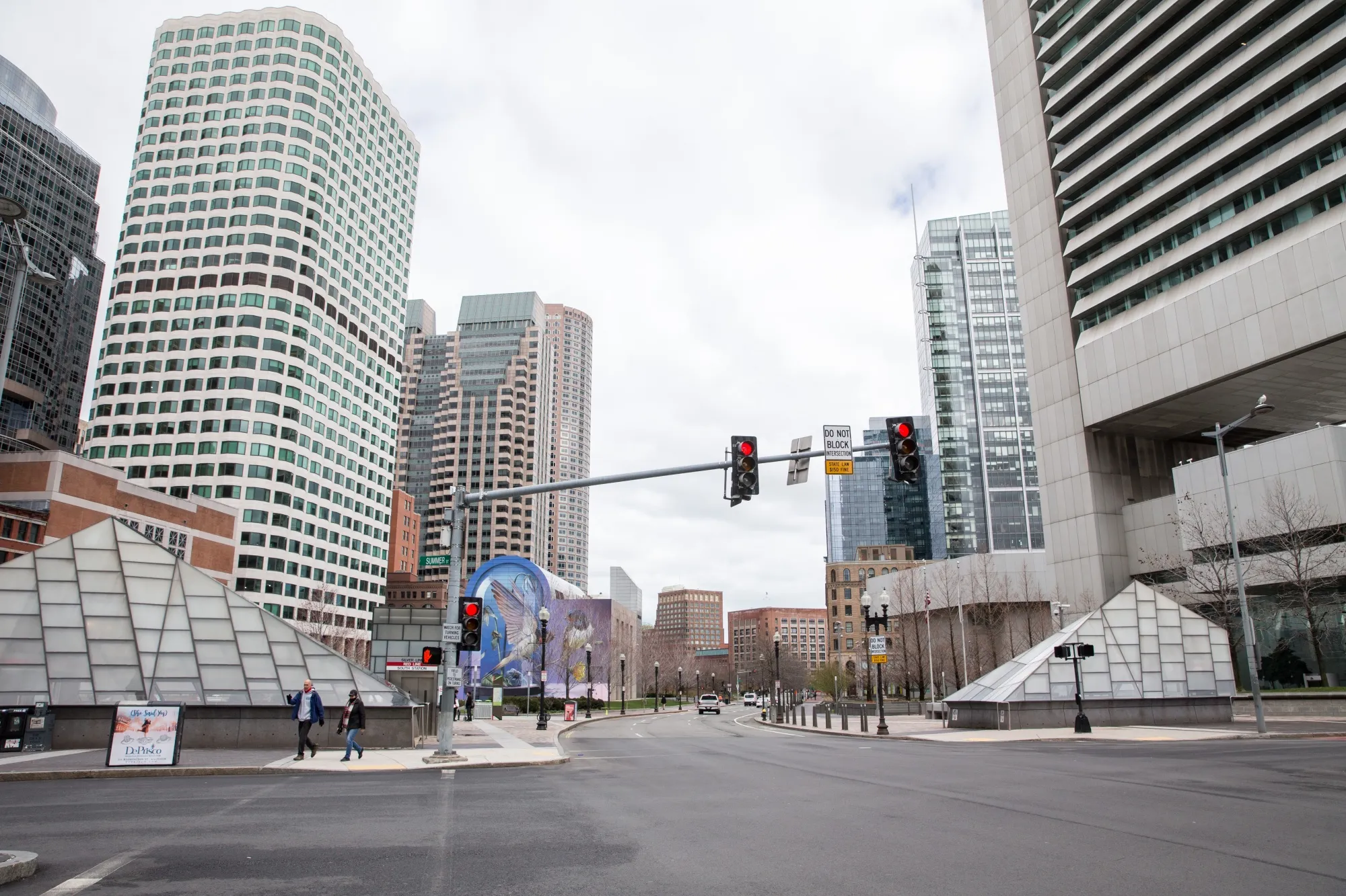 Pedestrians walk down empty streets near South Station in Boston on March 24. ESG investors are turning their focus to workers and how employers treat them during the pandemic.