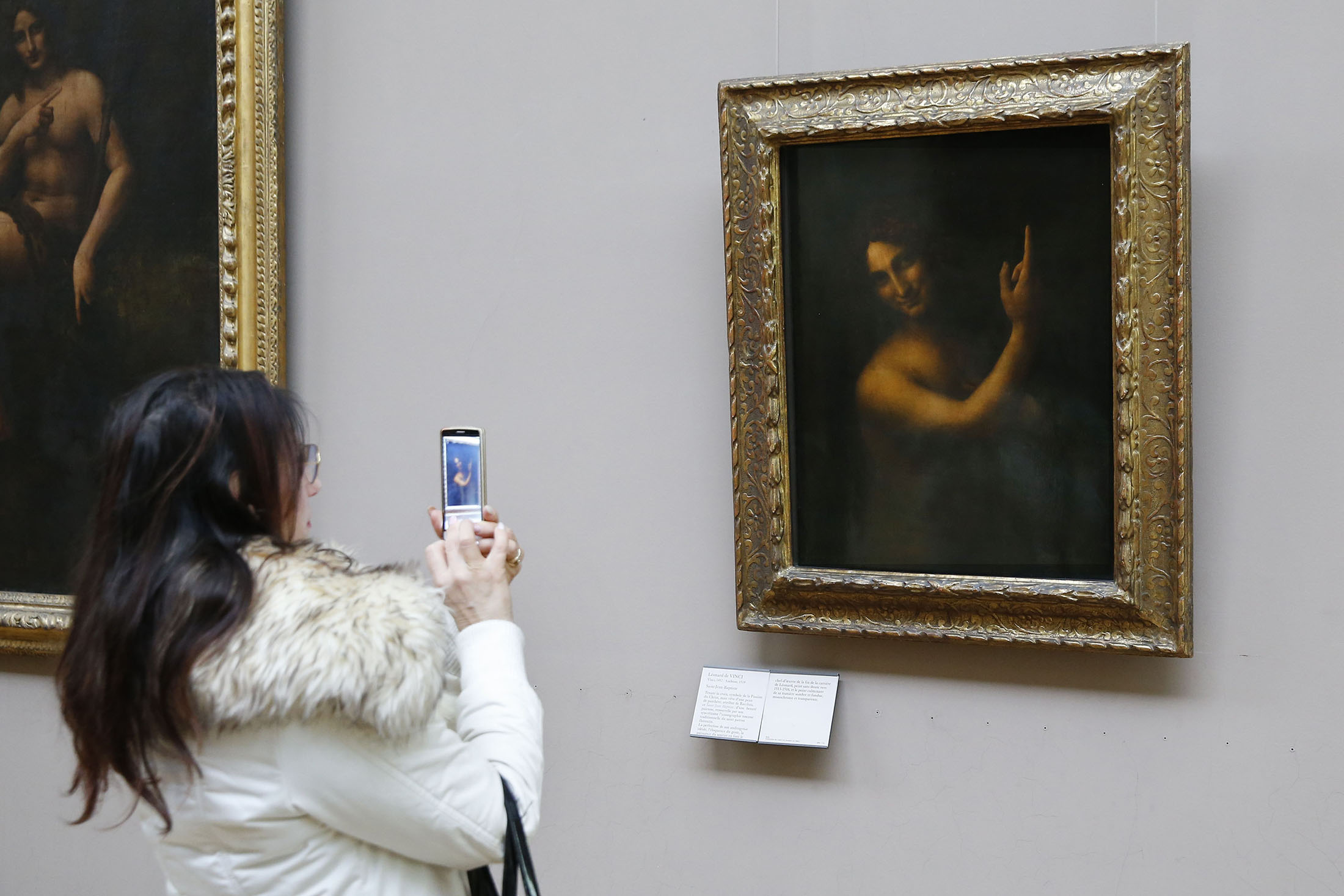 A woman takes a picture&nbsp;of &quot;Saint-Jean Baptiste&quot; by Leonardo da Vinci in the Louvre on Jan. 13, 2016.