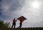 Electricians install solar panels on a roof for Arizona Public Service company in Goodyear, Arizona.