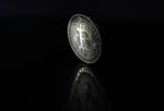 A bitcoin token stands in this arranged photograph.