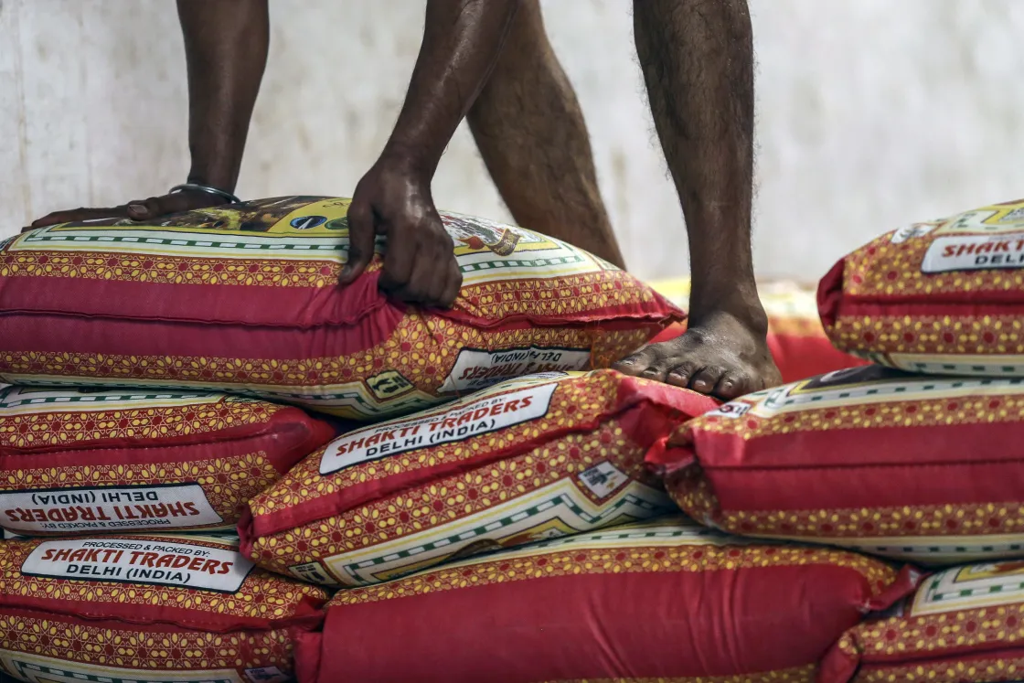 A worker stacks bags of basmati rice at a warehouse&nbsp;in Mumbai.