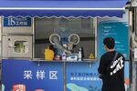 A healthcare worker at a Covid-19 testing booth during a lockdown in Shanghai.