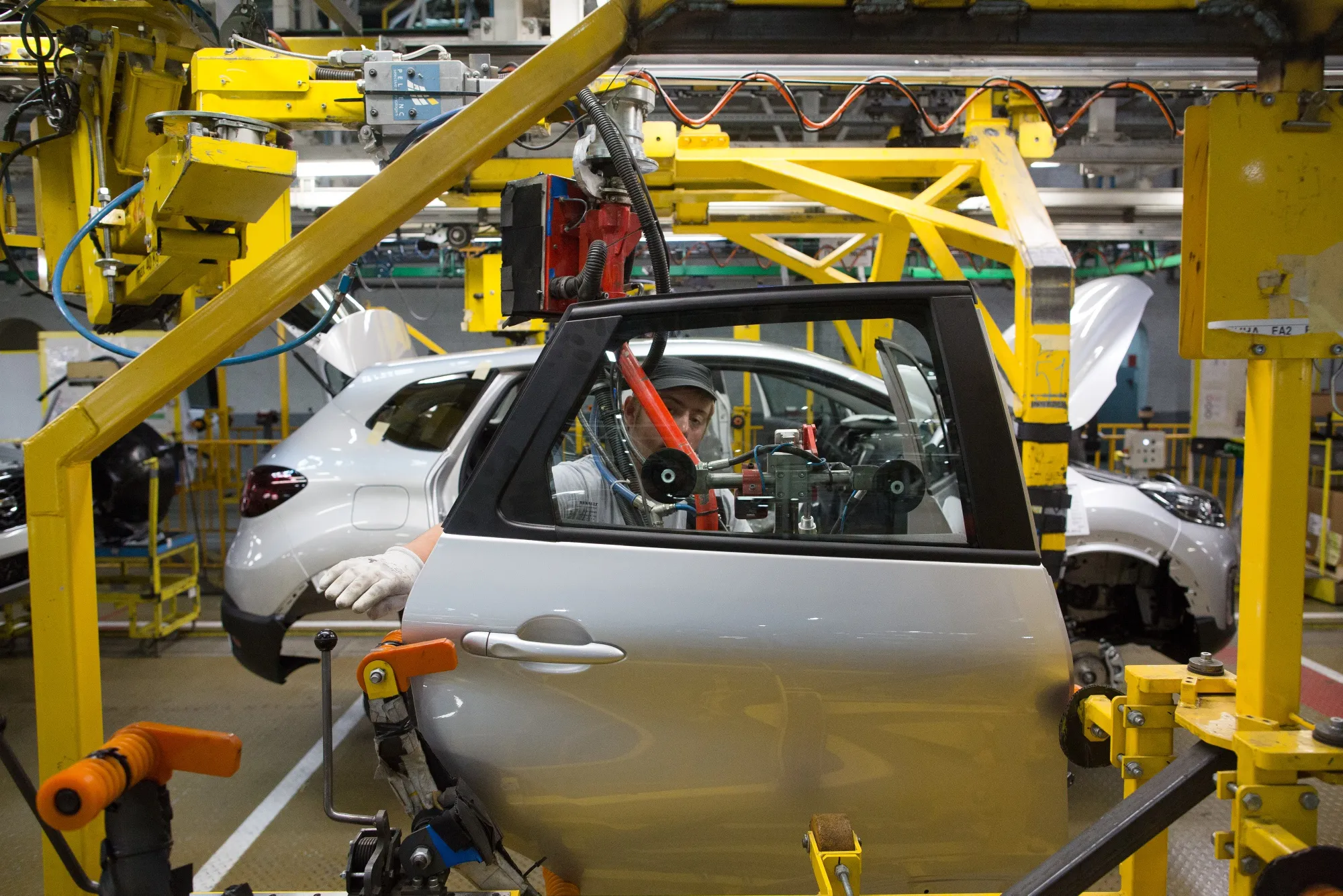A worker prepares to install a rear door into a Renault Captur crossover sport utility vehicle.&nbsp;