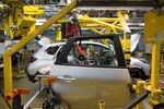 A worker prepares to install a rear door into a Renault Captur crossover sport utility vehicle.&nbsp;