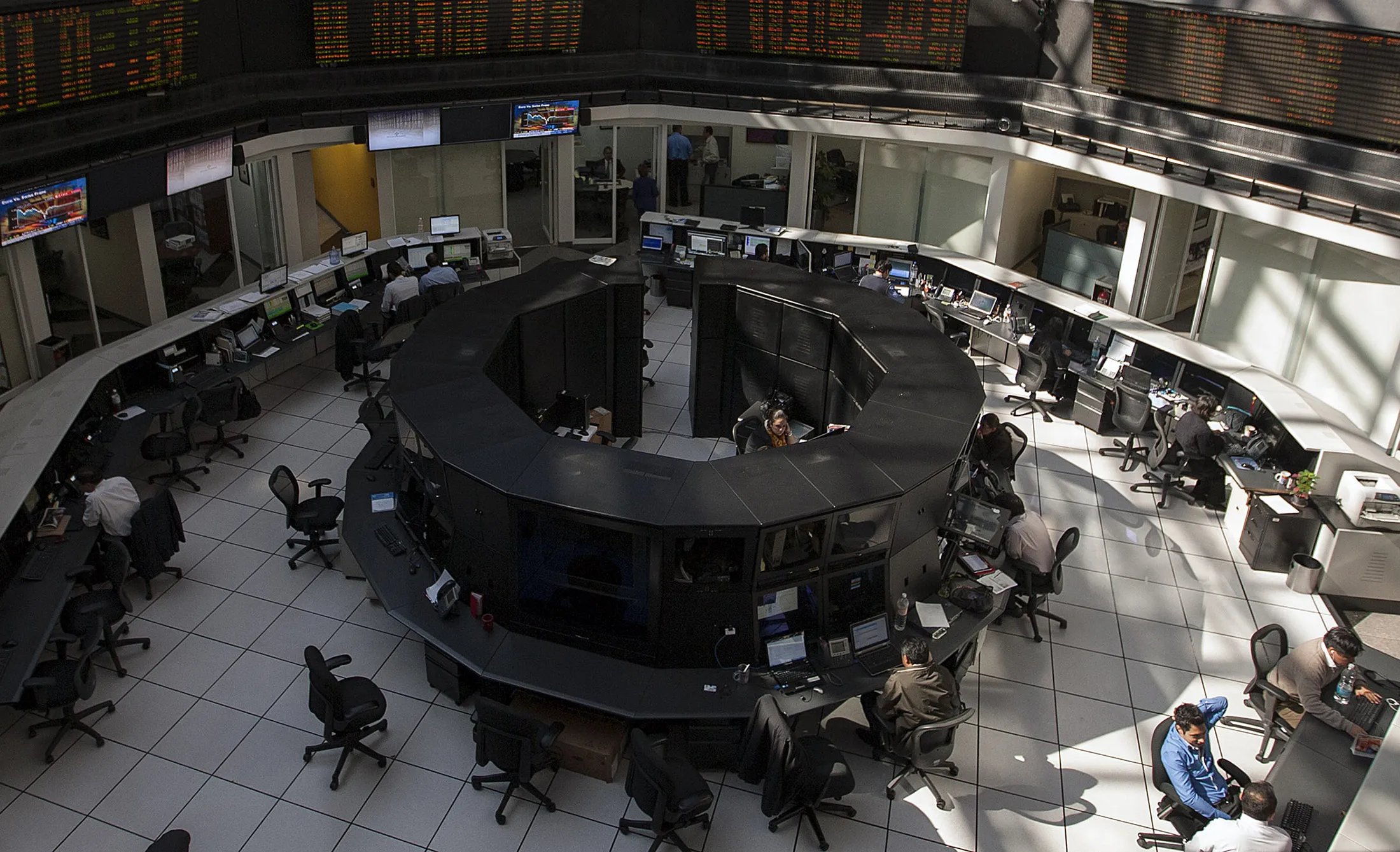 Traders work on the floor of the Bolsa Mexicana de Valores (BMV), Mexico's stock exchange, in Mexico City, Mexico, on Monday, Oct. 15, 2012. Emerging-market stocks fell for the first time in three days as global policy makers clashed on ways to boost economic growth and Chinese companies from ZTE Corp. To Yunnan Copper Industry Co. predicted losses.
