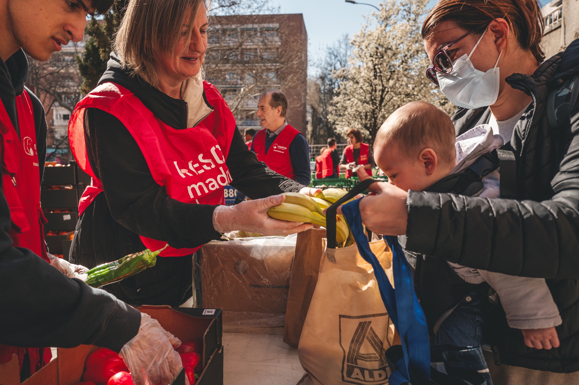 A mother receives bananas and peppers at the Fundacion Madrina in Madrid, Spain, on Friday, March 13, 2026.