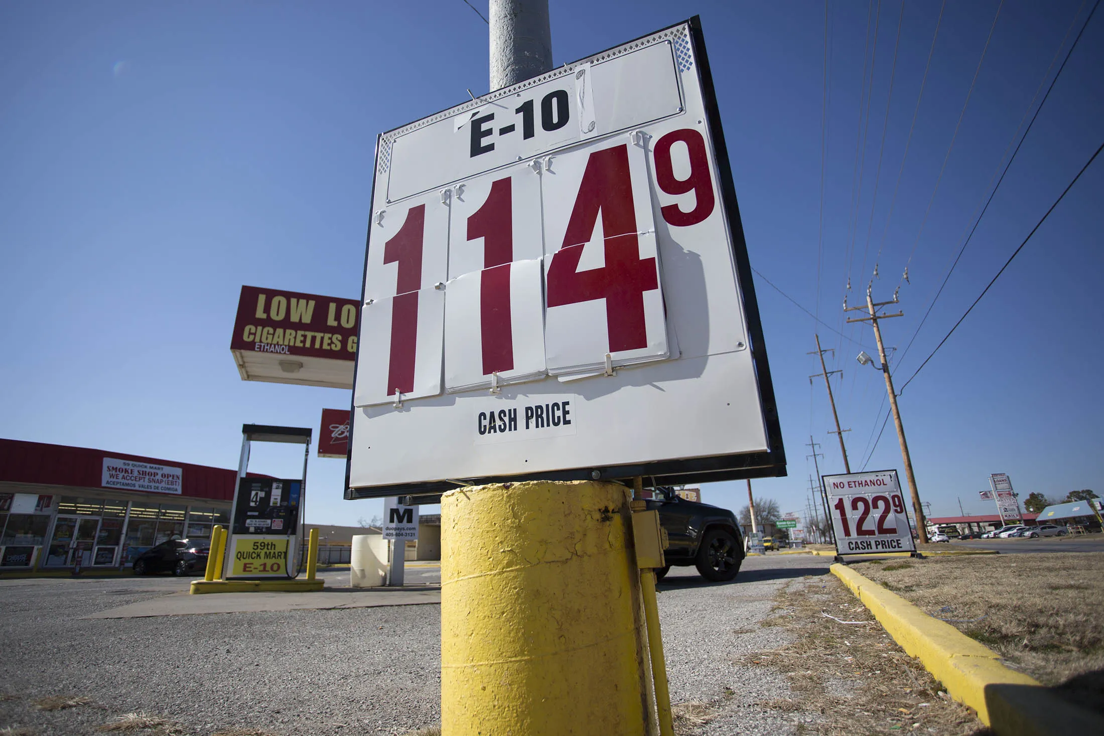 Signs in front of a gas station reflect lower gas prices.
