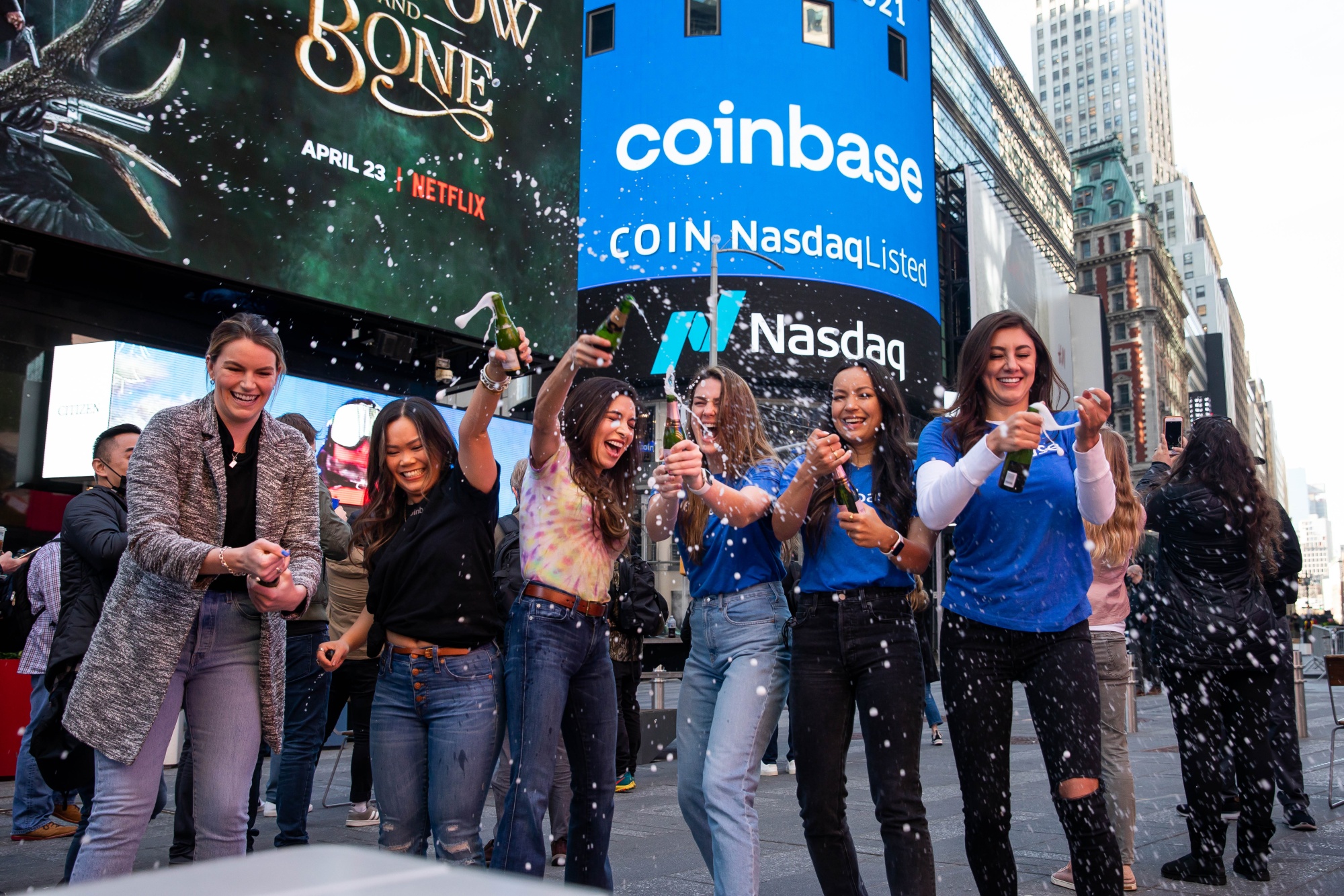 Coinbase employees spray champagne during the company's initial public offering outside the Nasdaq MarketSite.