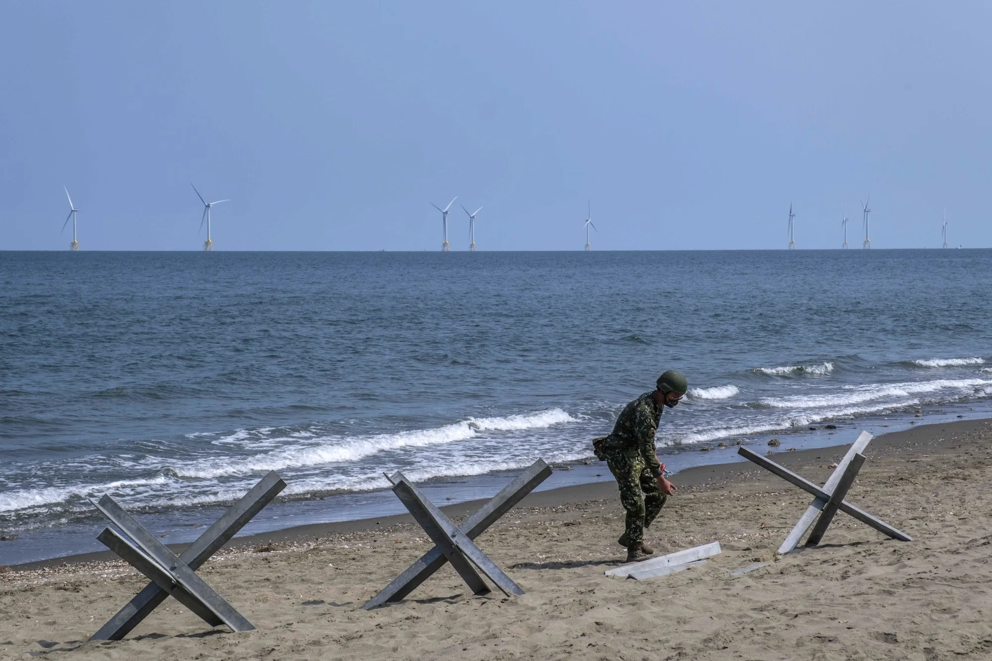 A soldier sets up barricades on a beach during a military exercise in Miaoli, Taiwan, in July.