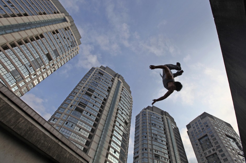 A youth jumps during a Parkour practice on top of a seven-floor building in Taizhou, Zhejiang province.
