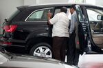 Customers inspect an SUV on display at a dealership in New Delhi, India.
