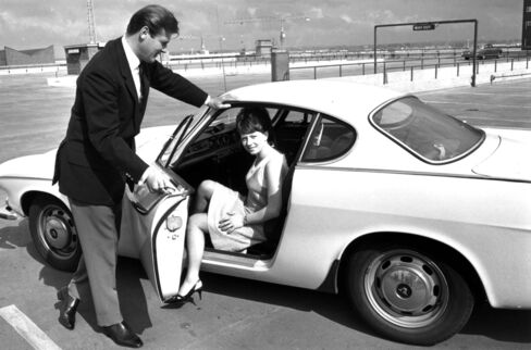 Roger Moore opens the door of his Volvo for Isabelle McMillan in a 1965 scene from 'The Saint.'