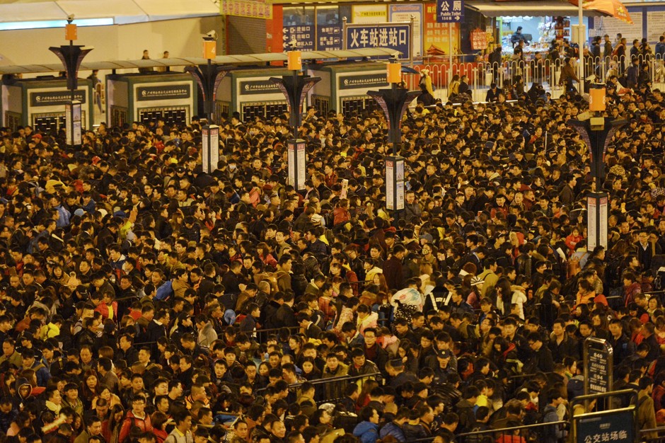 Passengers wait to enter a railway station after trains were delayed due to bad weather in Guangzhou.