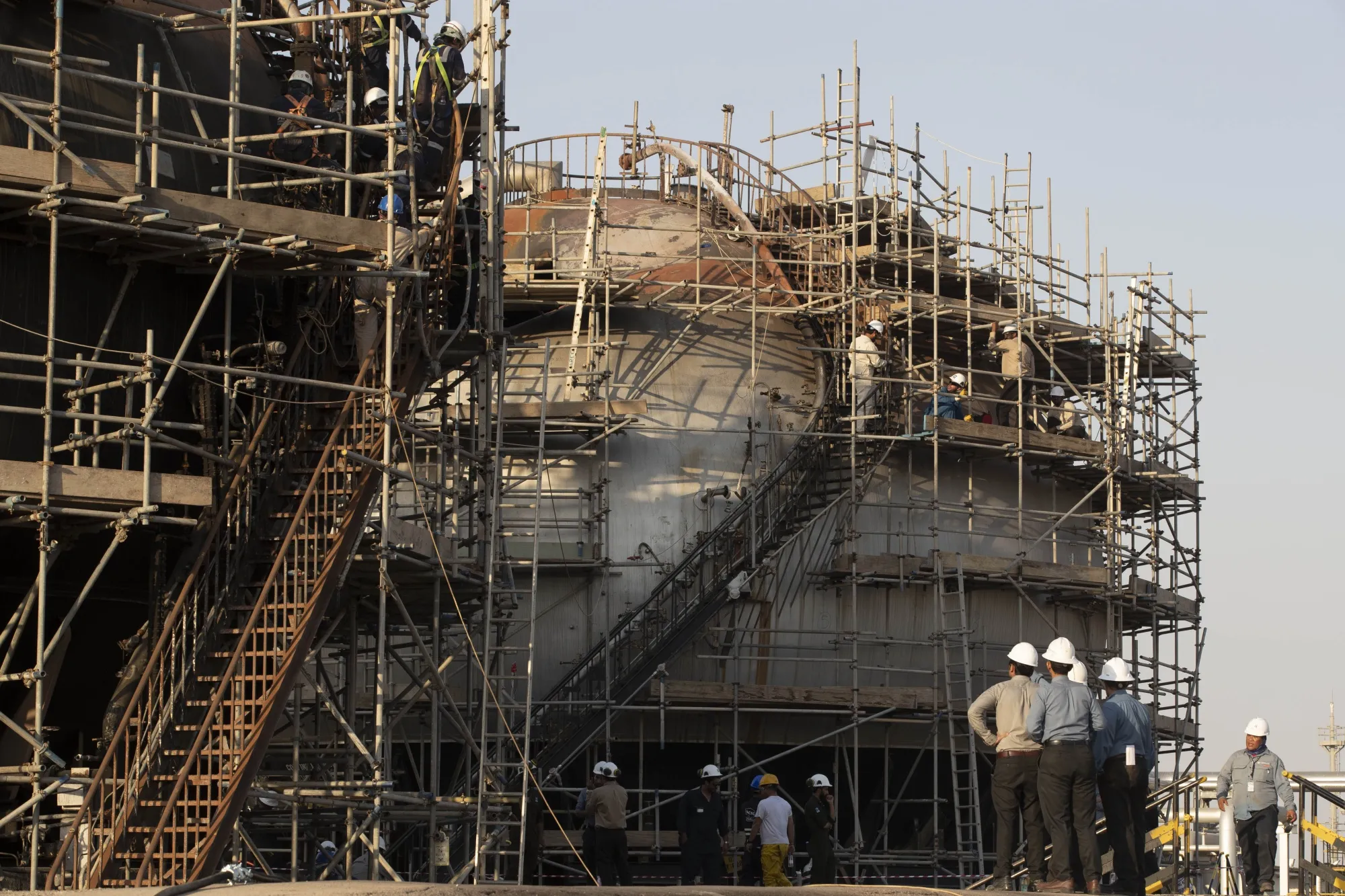 Workers repair a damaged tank at Saudi Aramco's Abqaiq processing plant following a drone attack in Abqaiq, 2019.&nbsp;
