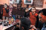 A youth shows off his bootleg pistol in a Cairo barbershop
