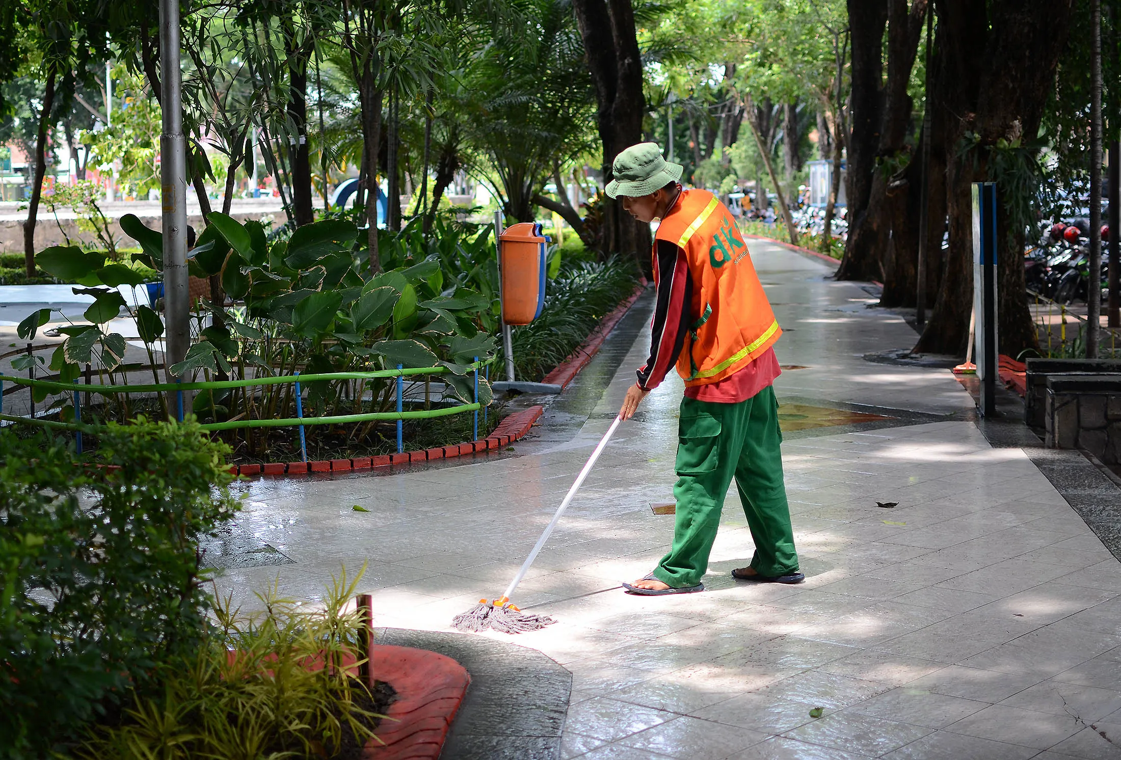 A janitor mops the floor at Bungkul Park in Indonesia.
