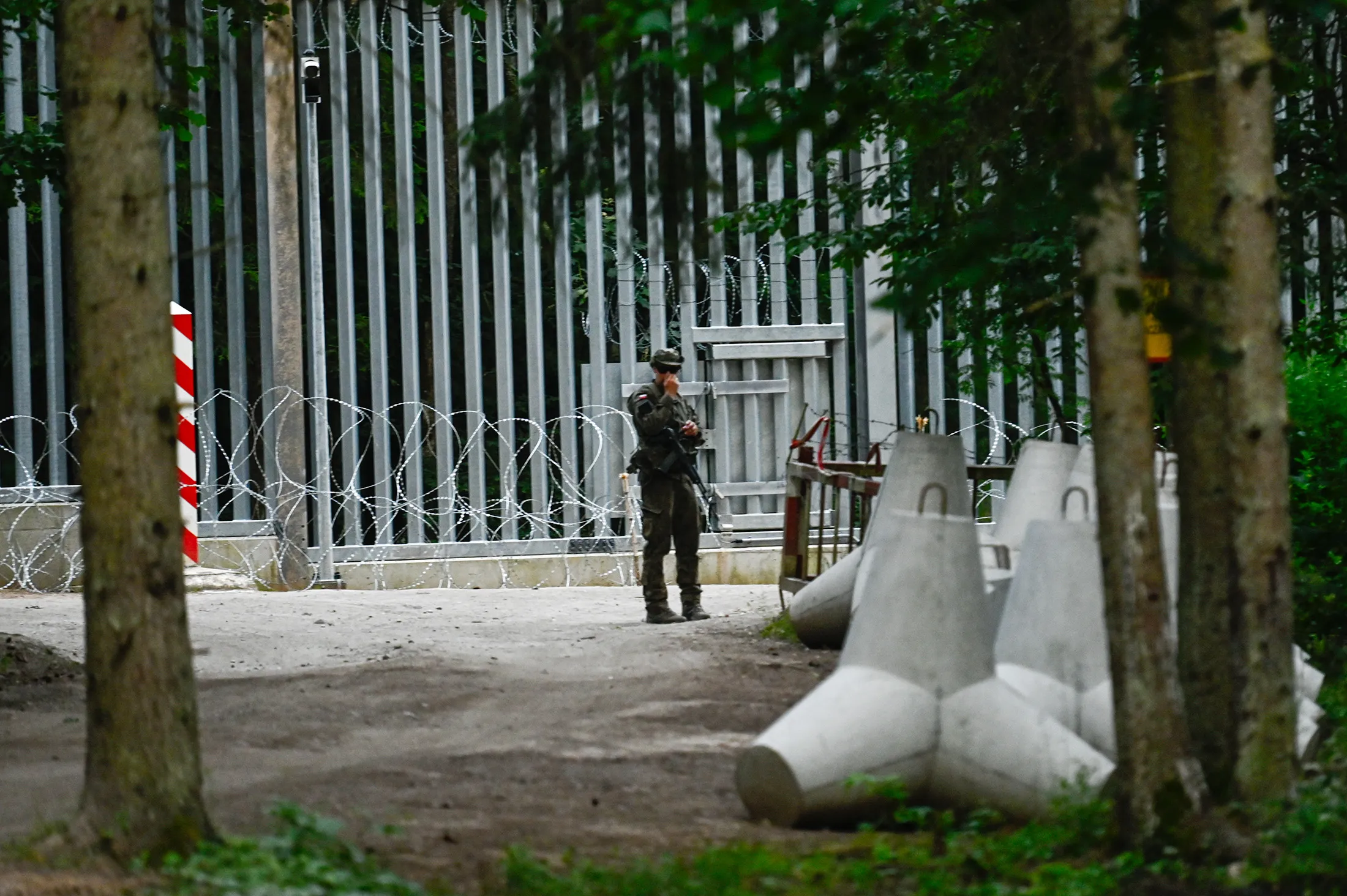 A Polish soldier stands by anti-tank obstacles near the metal wall constructed at the Polish-Belarussian border in Bialowieza, Poland,&nbsp;on July 8.
