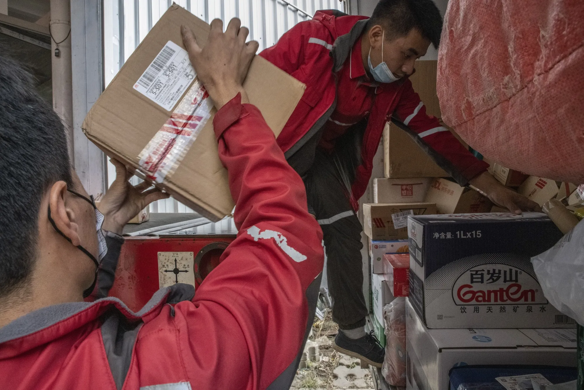 Delivery workers unload parcels from a truck at a JD.com sorting center in Beijing.