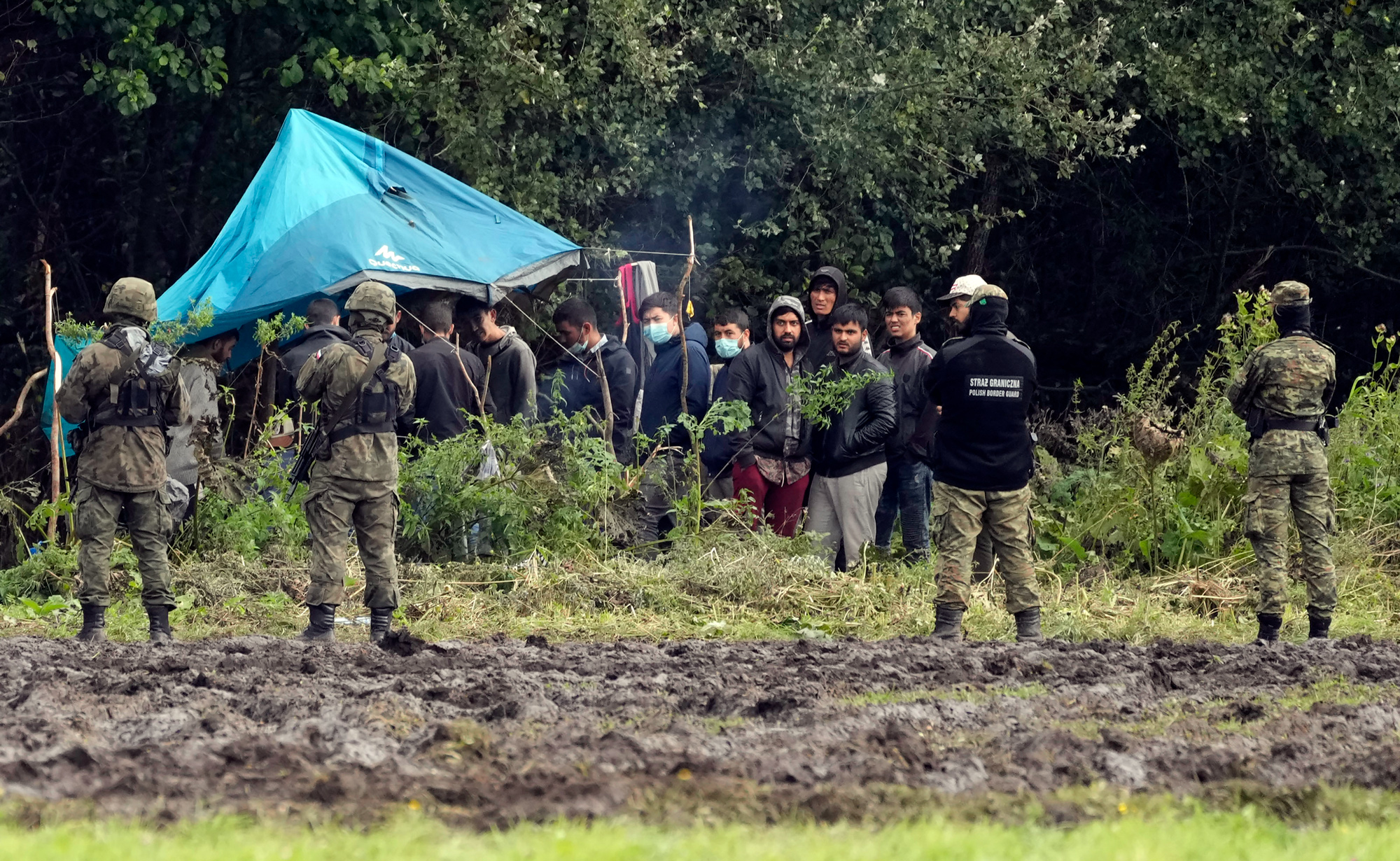 Polish security face migrants on the border with Belarus in Usnarz Gorny, Poland, in September.