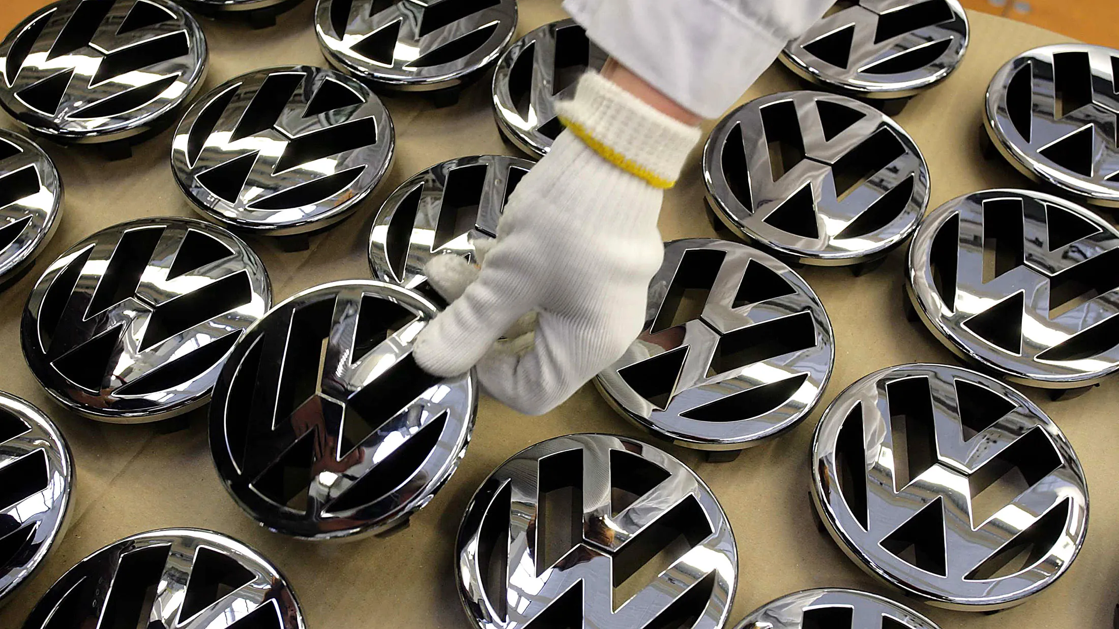A worker chooses a logo to place on a VW Golf car on the production line in Wolfsburg, Germany.

