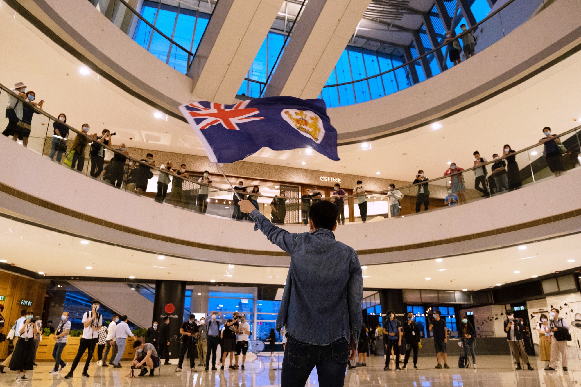 A demonstrator waves a colonial-era Hong Kong flag during a protest against a planned national security law held in the International Finance Center shopping mall in Hong Kong, on May 25.