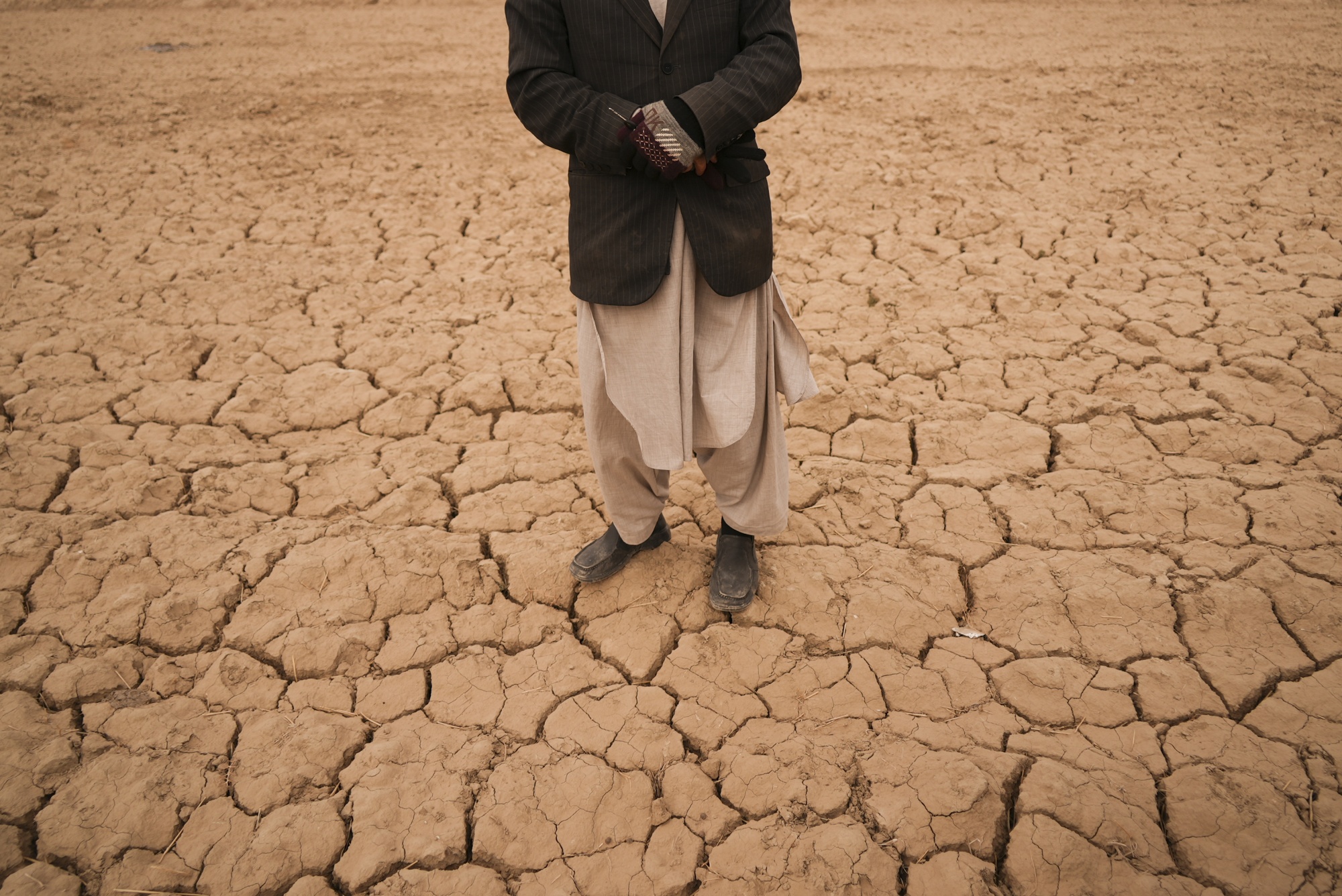 A man stands in his&nbsp;field where he used to grow wheat&nbsp;in Hachka, Afghanistan, on&nbsp;Dec. 13, 2021.