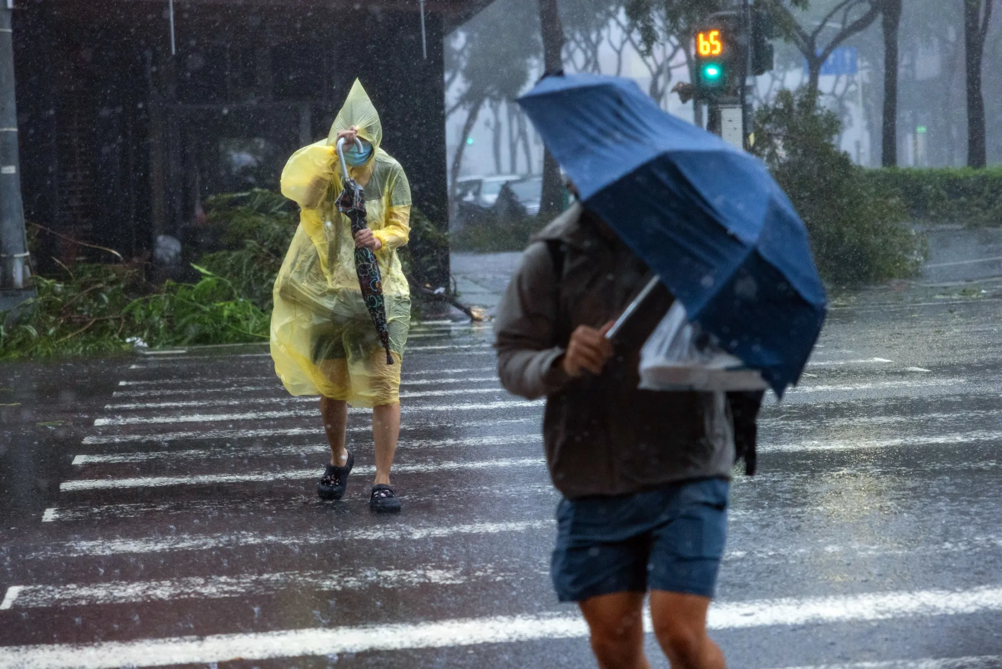 People cross a street as Typhoon Krathon makes landfall on in Kaohsiung, Taiwan, on Oct. 3.