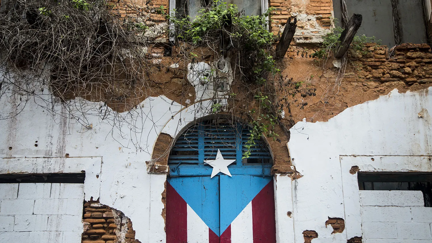 A Puerto Rican flag is seen painted on the doorway of an abandoned building in San Juan, Puerto Rico, on May 1, 2016.
