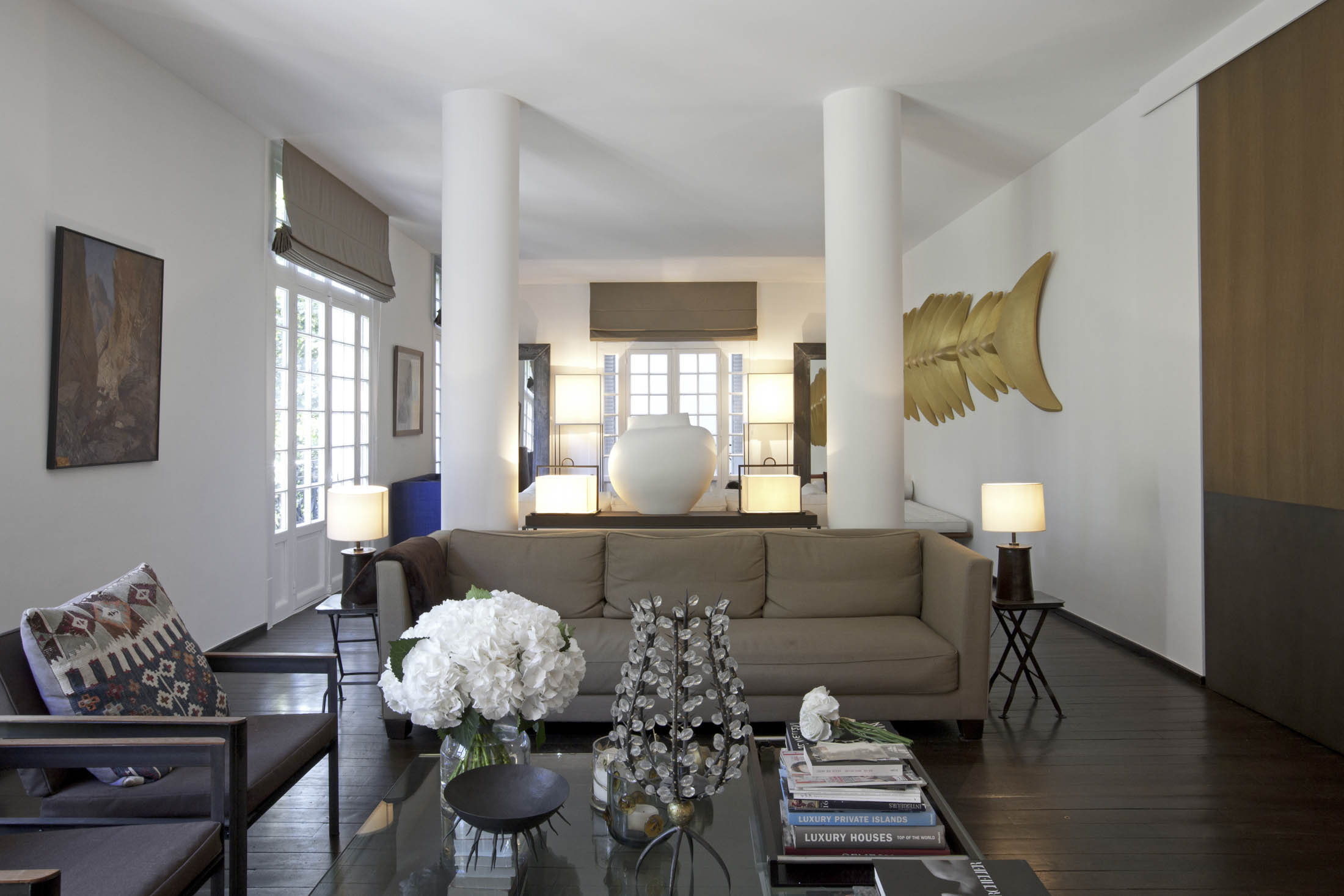 The living room's eclectic mix of furniture and objects includes a gold fish skeleton.