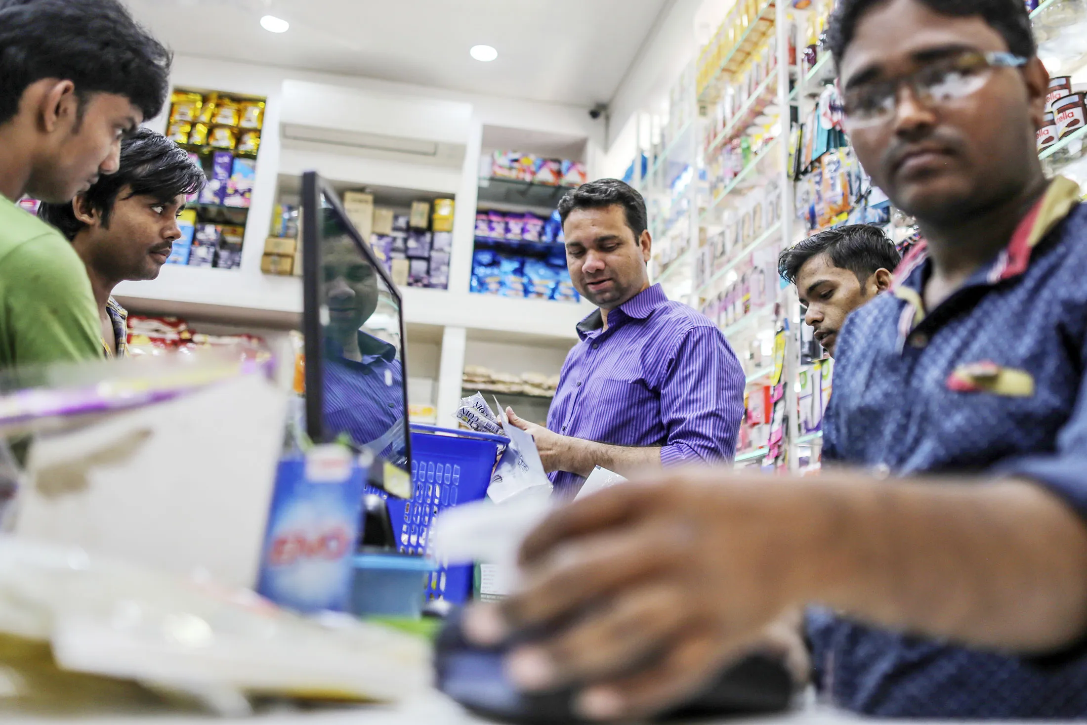 Employees work at a checkout counter of a supermarket in the Kurla area of Mumbai, India.
