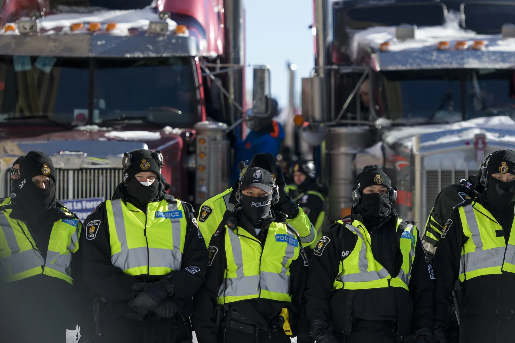 Police form a line to push back protesters as they work to clear the trucker convoy out of downtown Ottawa on Feb. 18, after more than three weeks of gridlock.