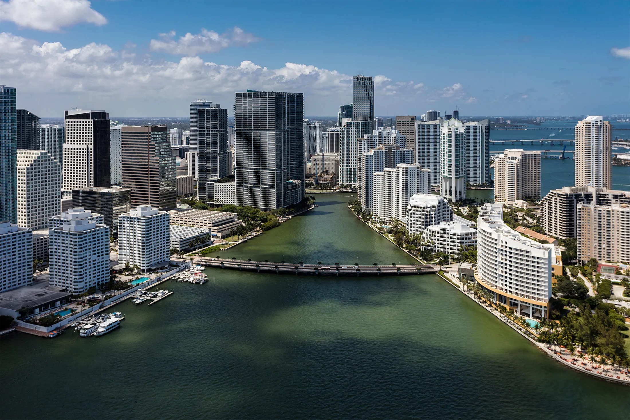 Aerial shot looking north at Skyscrapers and buildings along Miami River, Brickell Key Dr on a beautiful sunny day in downtown Miami Florida