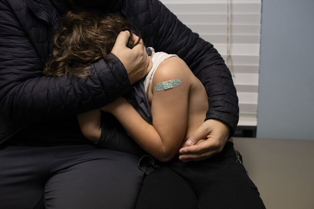 A child embraces a parent after receiving a dose of the Pfizer-BioNTech Covid-19 vaccine at a pediatric's office in West Bloomfield, Michigan, U.S., on Thursday, Nov. 4, 2021. Younger children, ages 5 to 11-year-old, across the U.S. are now eligible to receive Pfizer Inc.'s Covid-19 vaccine, after the head of the Centers for Disease Control and Prevention granted the final clearance needed for shots to begin.