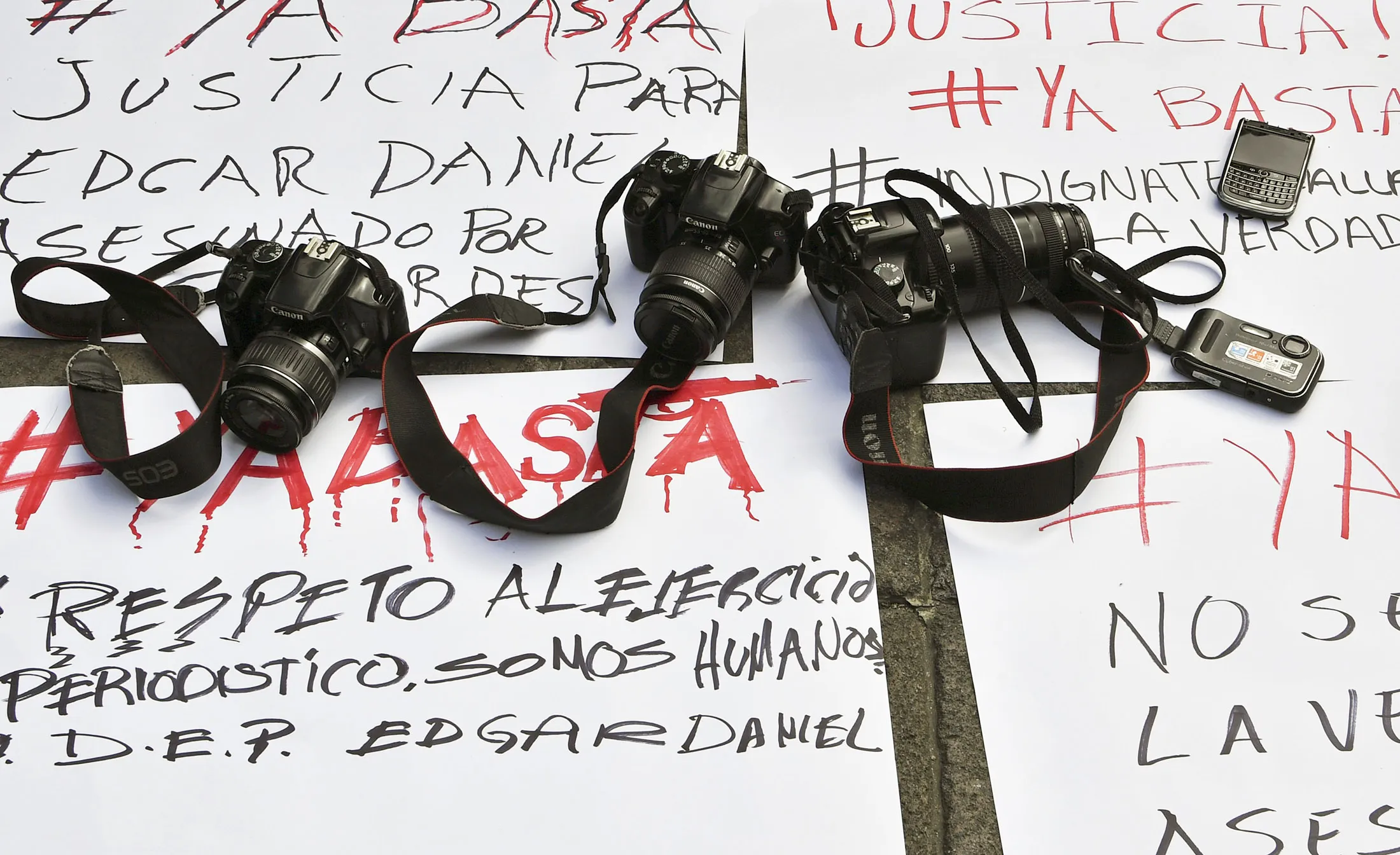 Cameras are placed on banners with messages of protest during a demonstration by photojournalists to demand justice for slain Mexican collegue Edgar Daniel Castro in front of the government's palace in San Luis Potosi, Mexico on October 6, 2017. Castro was kidnapped from his house by gunmen and was found dead on Friday in San Luis Potosi. / AFP PHOTO / YURI CORTEZ        (Photo credit should read YURI CORTEZ/AFP/Getty Images)