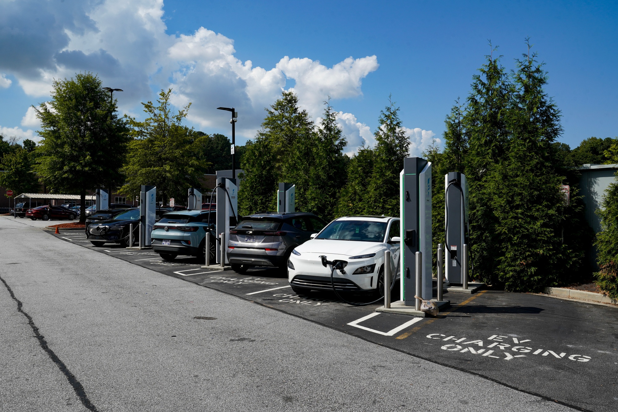 Electric vehicles (EV) at an Electrify America charging station in Atlanta, Georgia, US, on Wednesday, Aug. 28, 2024. Election swing states and rural tribal communities are among dozens of recipients of $521 million in grants to build more charging stations for electric vehicles, the Biden administration announced Tuesday. Photographer: Megan Varner/Bloomberg