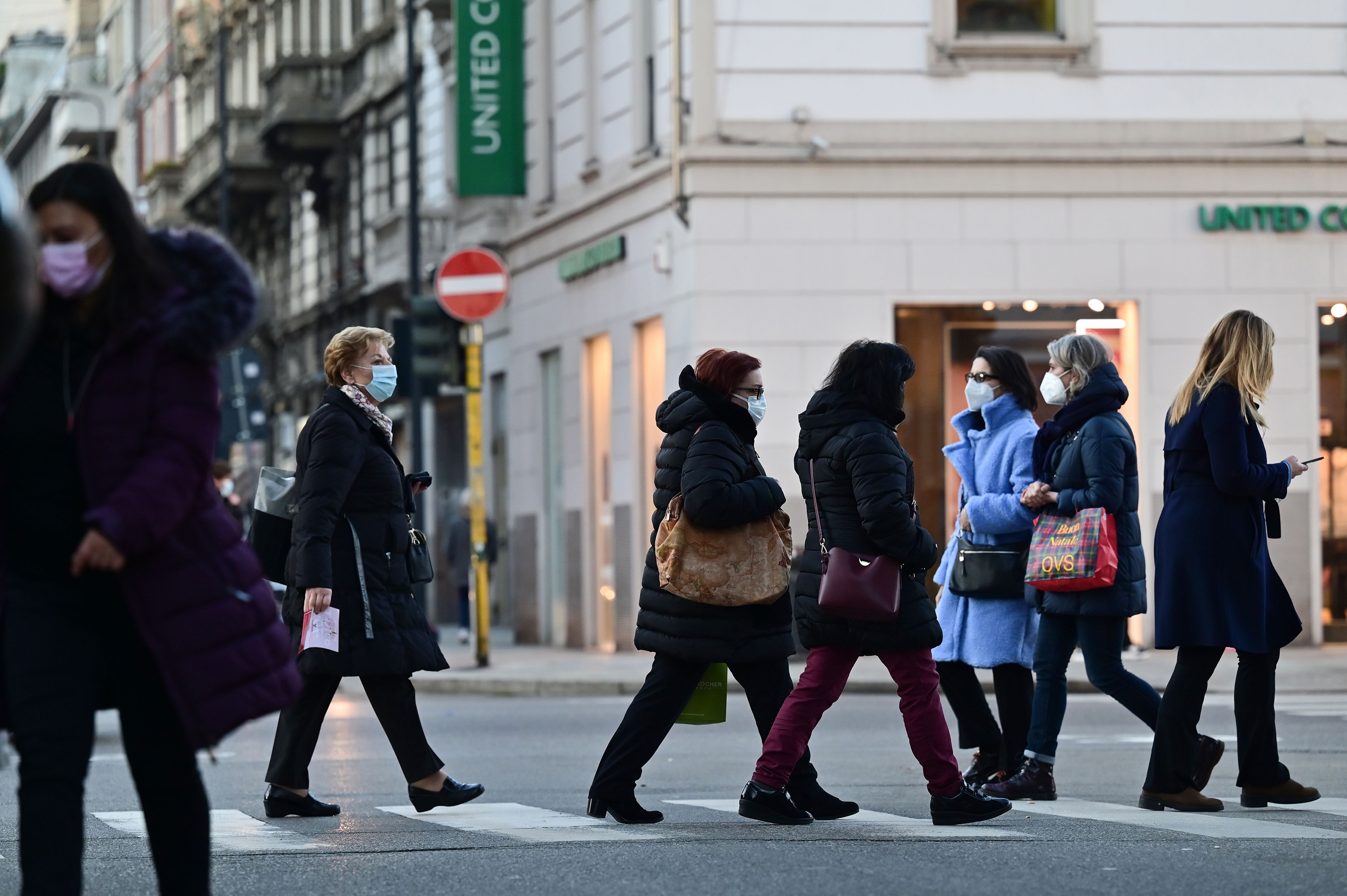I pedoni indossano maschere per il viso nel centro di Milano il 13 gennaio.  Il governo italiano ha scelto un sistema a tre livelli basato su restrizioni regionali generalmente più morbide rispetto alle misure adottate la scorsa primavera.