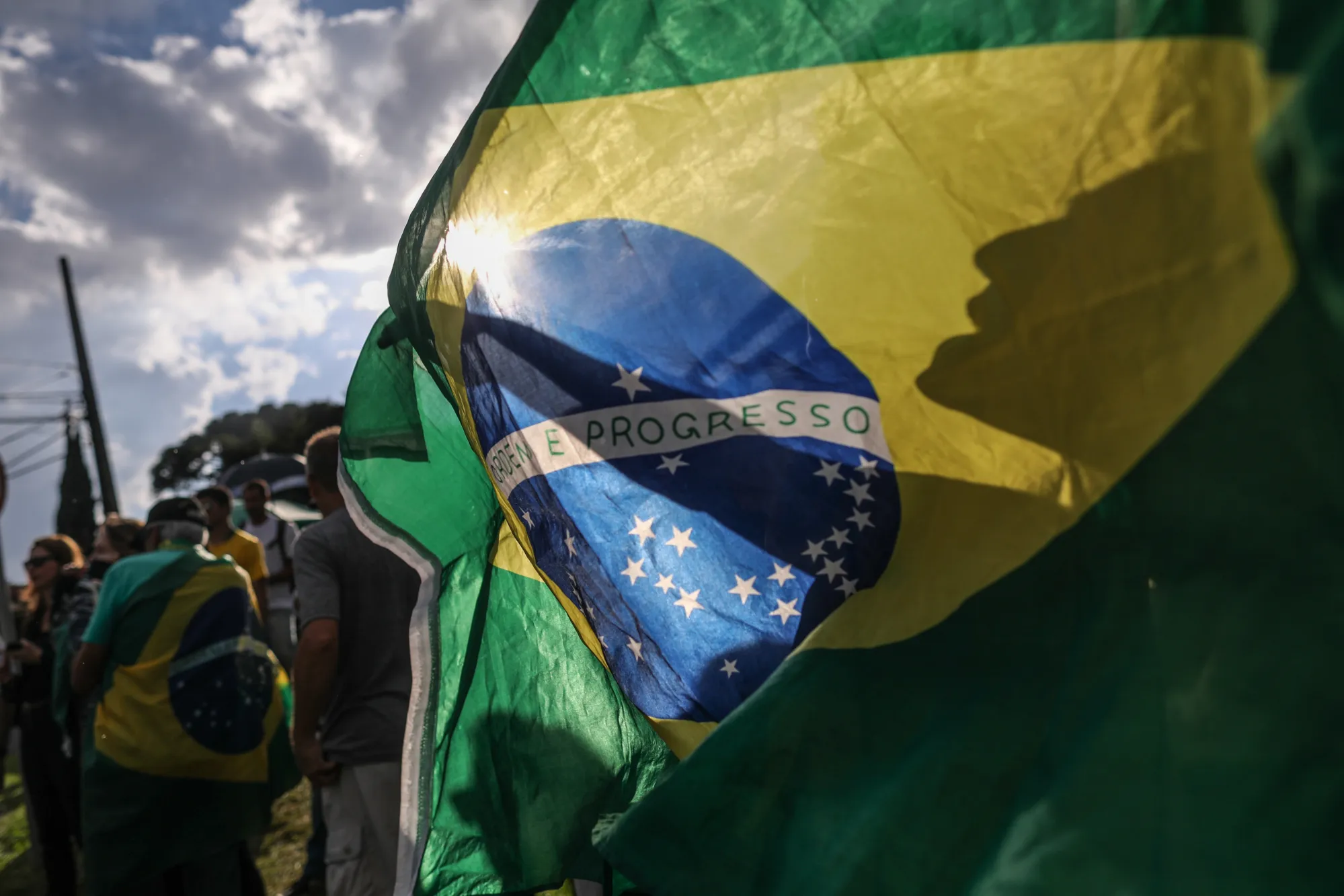 Demonstrators wave a Brazilian flag.