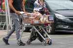 A customer pushes a shopping trolley of loaves of bread in the car park of a J Sainsbury Plc supermarket in London. 