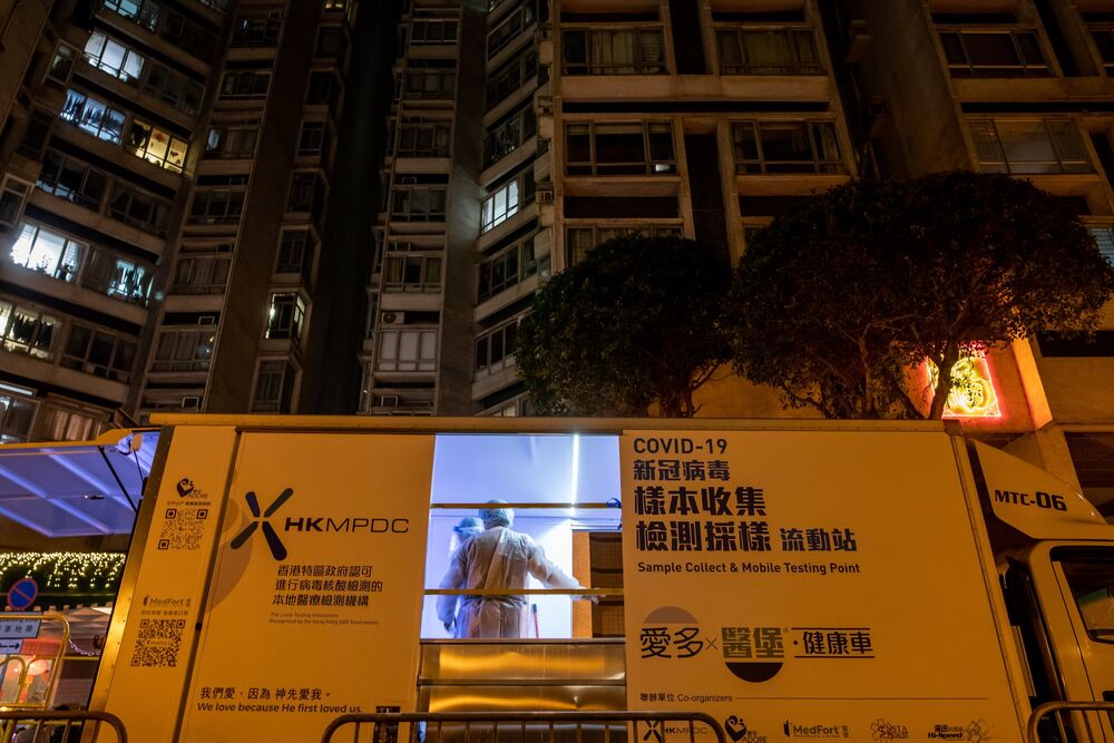 Government workers prepare a mobile testing unit outside a building under lockdown in the Kwun Tong neighborhood of Hong Kong, on Jan. 31.