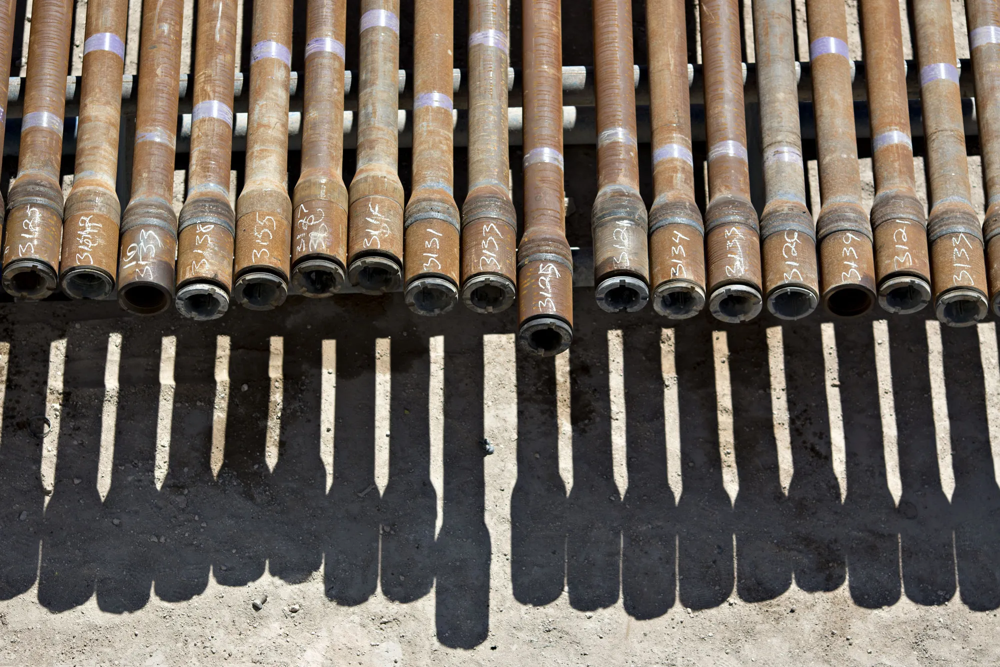 Oil drilling pipes sit on a rack
