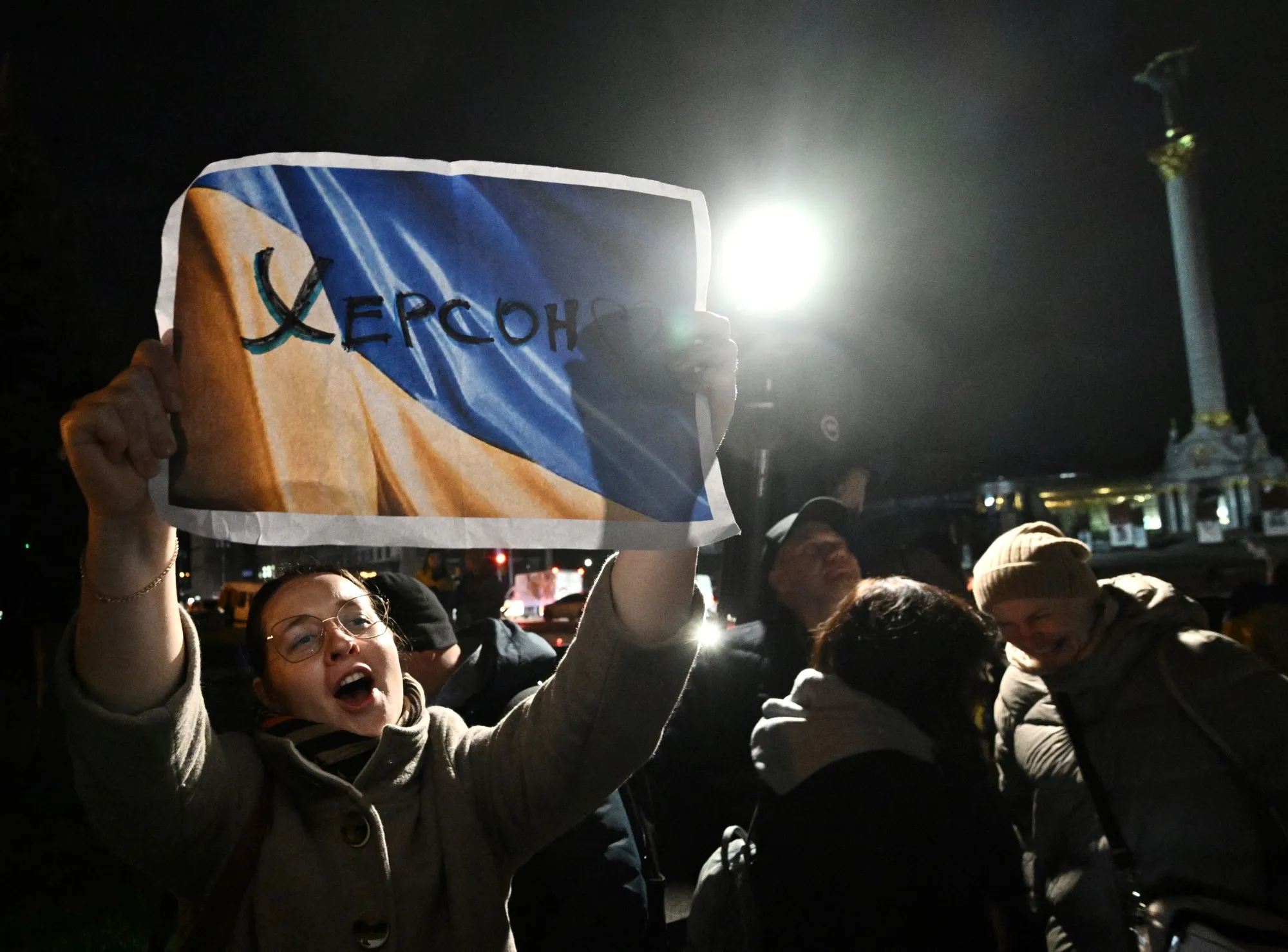 A woman holds a slogan which reads as "Kherson" as people gather in Maidan square to celebrate the liberation of Kherson, in Kyiv, on Nov.&nbsp;11.